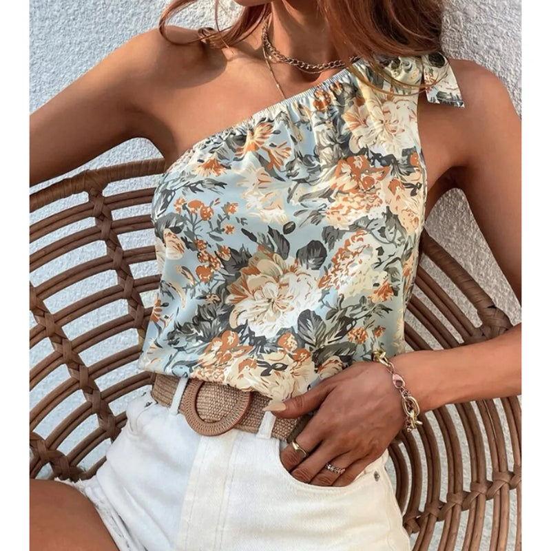 Frau mit Boho-Stil Strohgürtel, floraler One-Shoulder-Top, weiße Shorts, Sommermode.