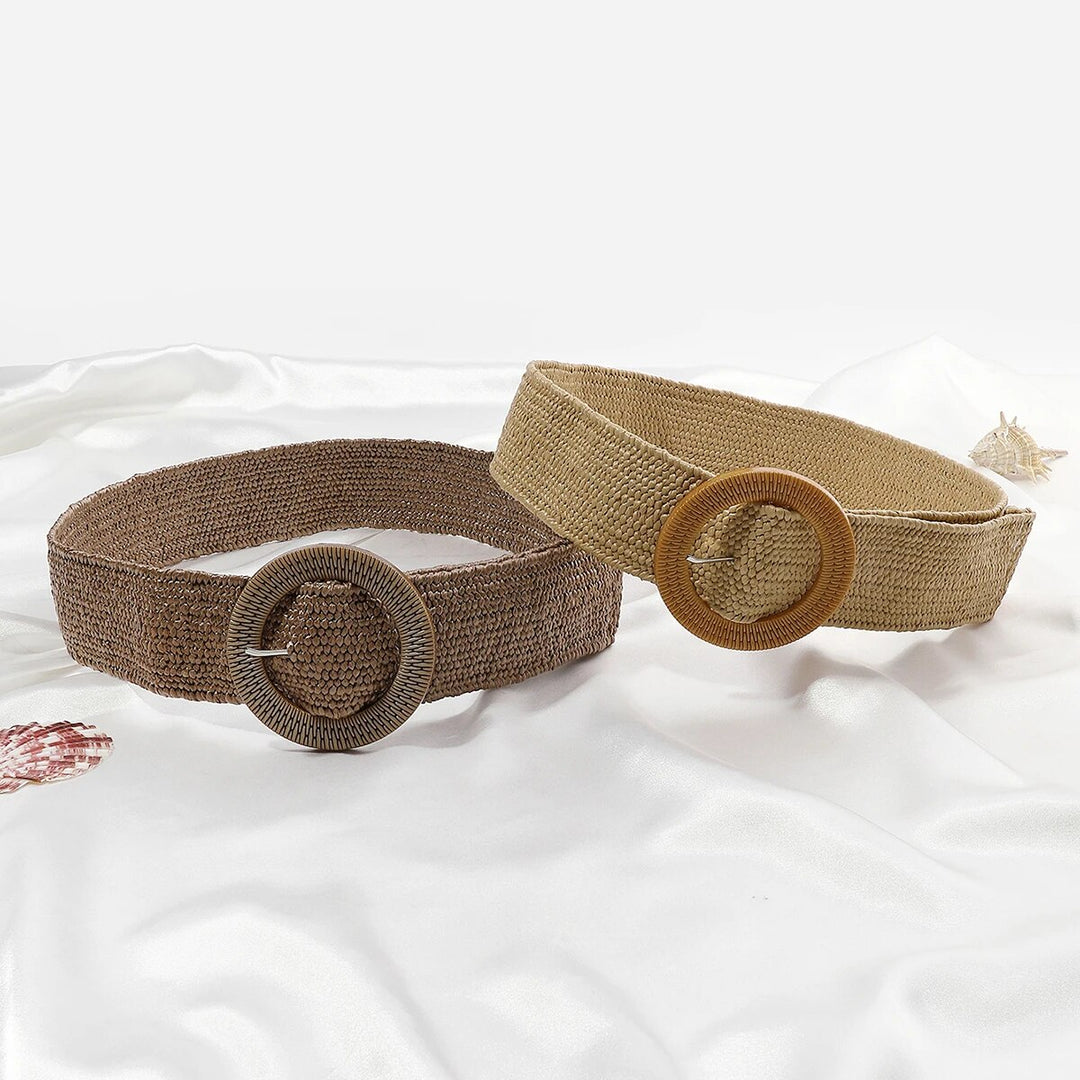 Zwei Boho-Stil Strohgürtel, braun und beige, mit runden Schnallen auf weißem Hintergrund.