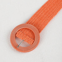 Orangefarbener, gewebter Strohgürtel mit runder Schnalle, Boho-Stil, modisches Accessoire.