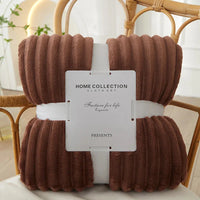 Braune, gerippte Decke aus Fleece, Home Collection, auf Rattan-Stuhl, gemütlich, dekorativ.