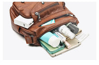 Braune Ledertasche mit Kosmetik, Smartphone und Tablet, ideal für Reisen und Alltag.