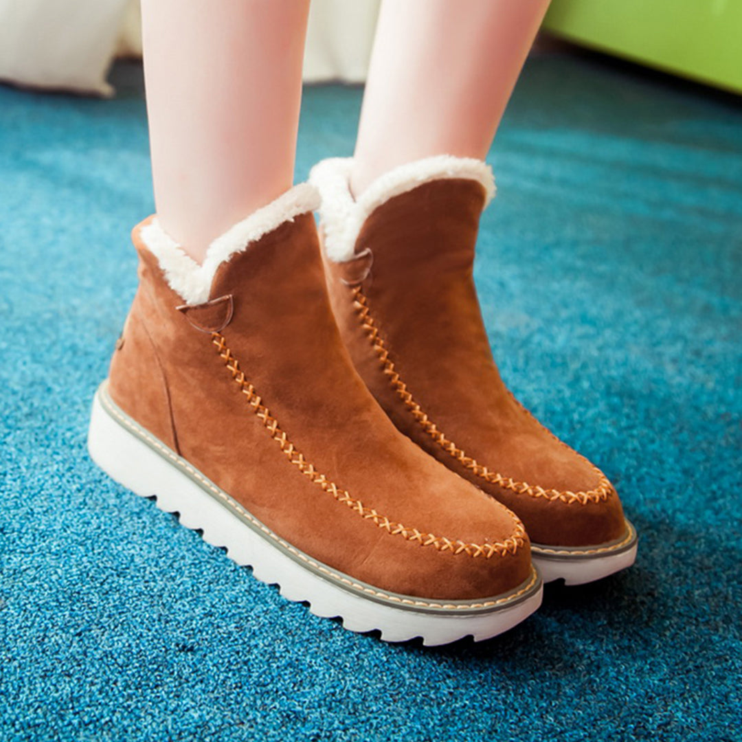 Braune Damen-Winterstiefel aus Wildleder mit weißem Kunstfellfutter und dicker Sohle.