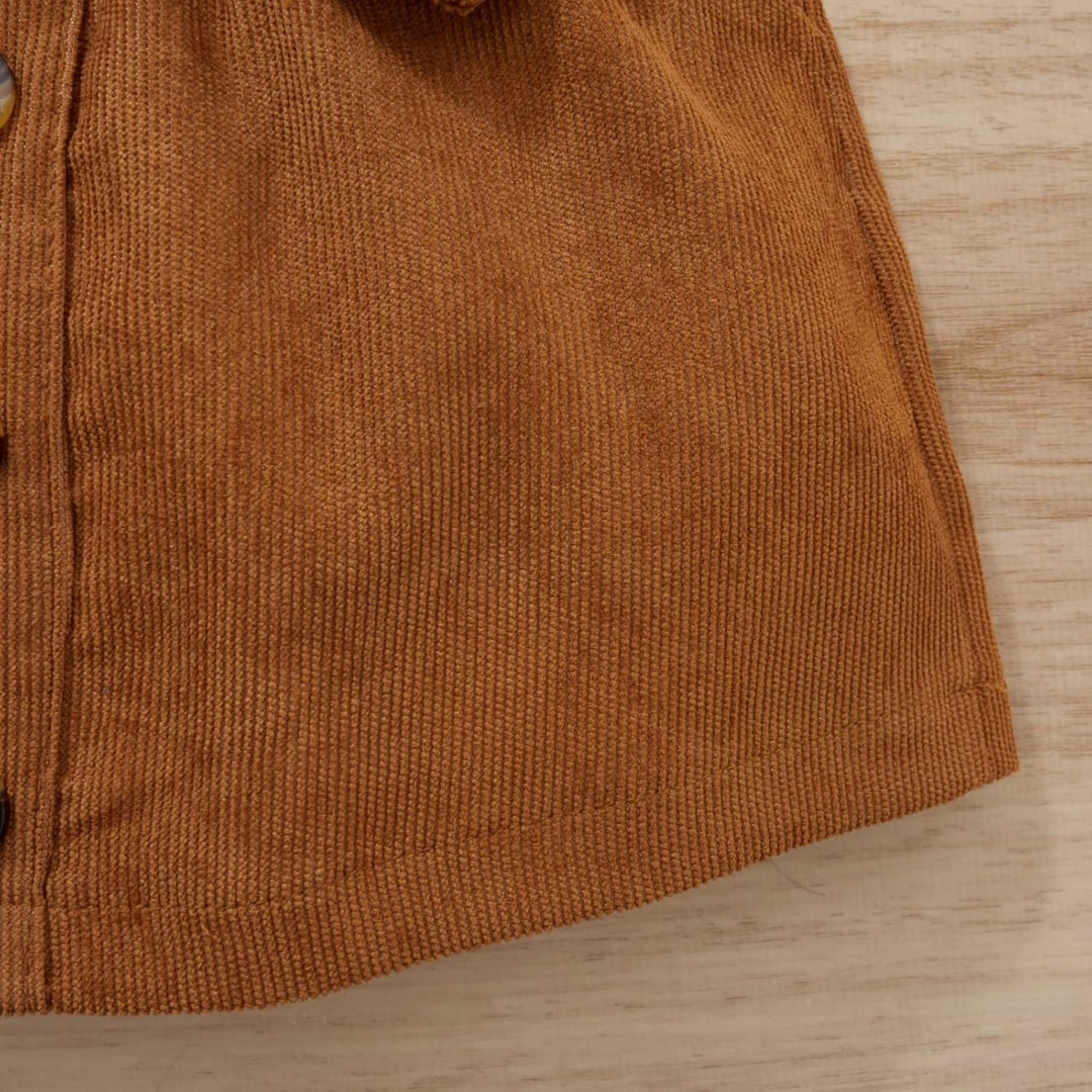 Braunes Cordhemd aus Baumwolle, Detailansicht, Knopfleiste, Herbstmode, Textur, Holzuntergrund.