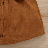 Braunes Cordhemd aus Baumwolle, Detailansicht, Knopfleiste, Herbstmode, Textur, Holzuntergrund.