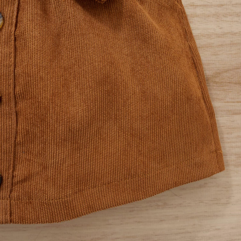 Braunes Cordhemd aus Baumwolle, Detailansicht, Knopfleiste, Herbstmode, Textur, Holzuntergrund.