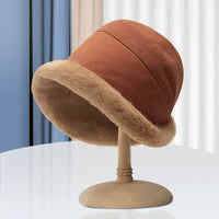 Brauner Damenhut mit Kunstfellrand auf Ständer, modisch, elegant, Herbst-Winter-Accessoire.
