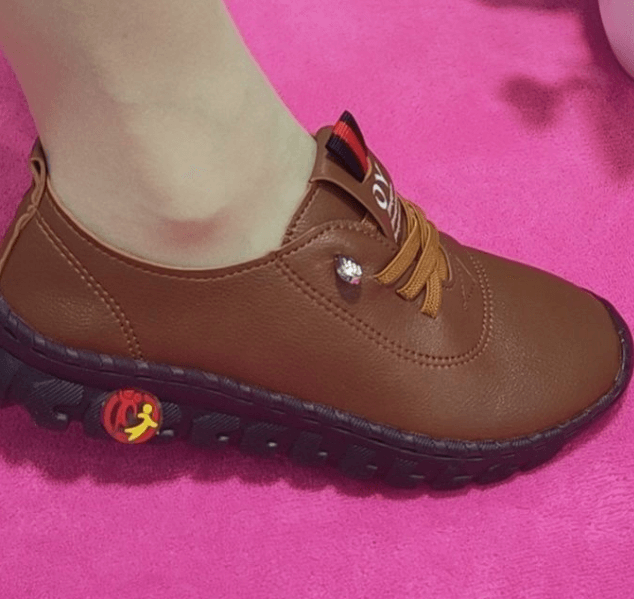 Brauner Lederschuh mit Gummisohle auf pinkem Hintergrund, sportlich, bequem, Damenmode.