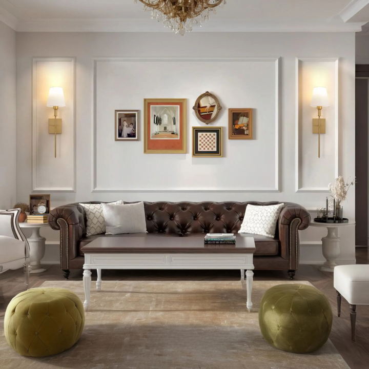 Luxuriöses Wohnzimmer mit braunem Chesterfield-Sofa, Wandbildern und grünen Poufs.