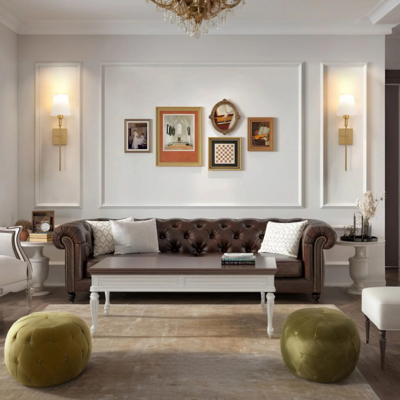 Luxuriöses Wohnzimmer mit braunem Chesterfield-Sofa, Wandbildern und grünen Poufs.