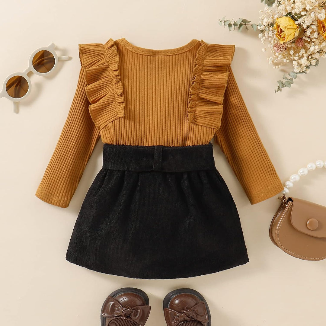 Braunes Kinderkleid mit Rüschen, schwarzer Rock, Sonnenbrille, Handtasche, Schuhe, Blumen.