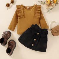 Braunes Rüschen-Oberteil und schwarzer Rock für Mädchen, Herbstmode, flache Lage.