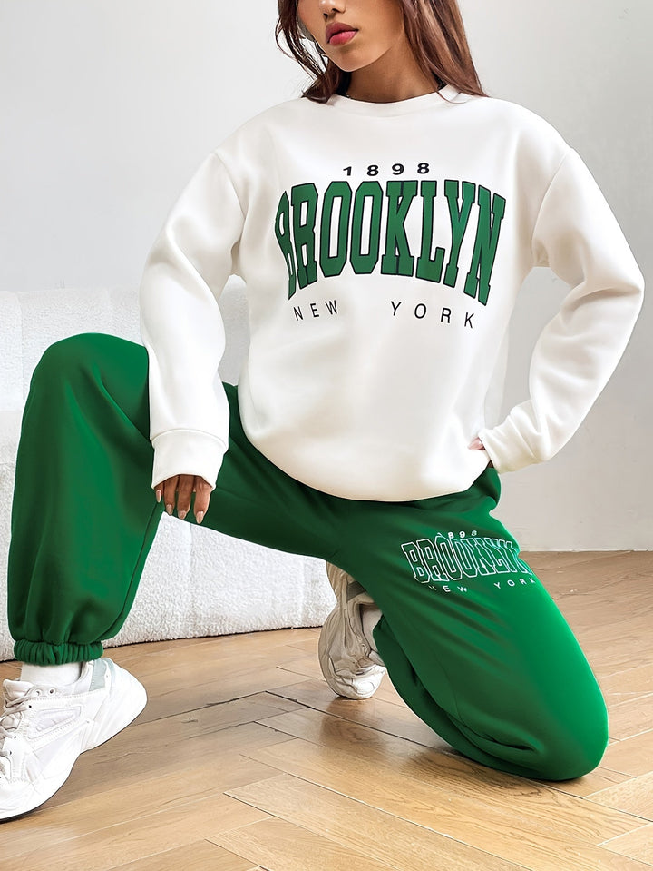 Frau in weißem Brooklyn-Sweatshirt und grüner Jogginghose, lässige Mode, Streetwear-Trend.