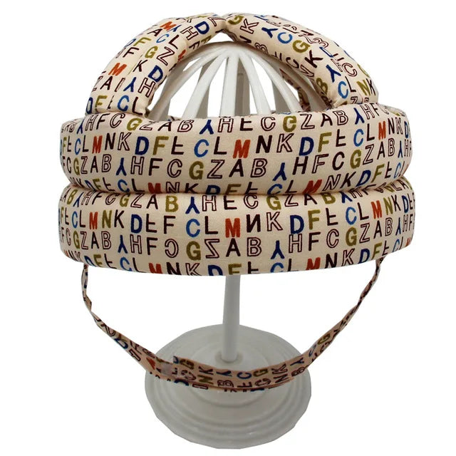 Bunter Buchstaben-Helm auf weißem Ständer, gepolstert, dekorativ, für Kinderzimmer.