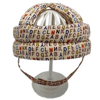 Bunter Buchstaben-Helm auf weißem Ständer, gepolstert, dekorativ, für Kinderzimmer.