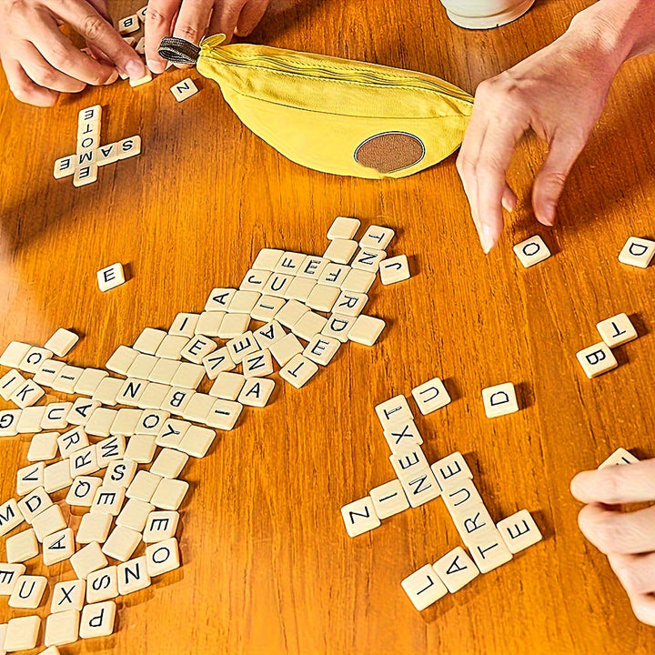 Hände spielen Bananagrams mit gelbem Beutel auf Holztisch, Buchstabensteine verteilt.