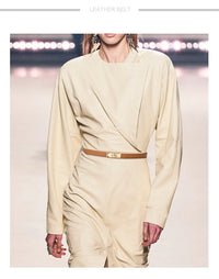 Damenmode: Cremefarbenes Kleid mit Designer-Gürtel, elegantes Outfit, Laufsteg-Look.