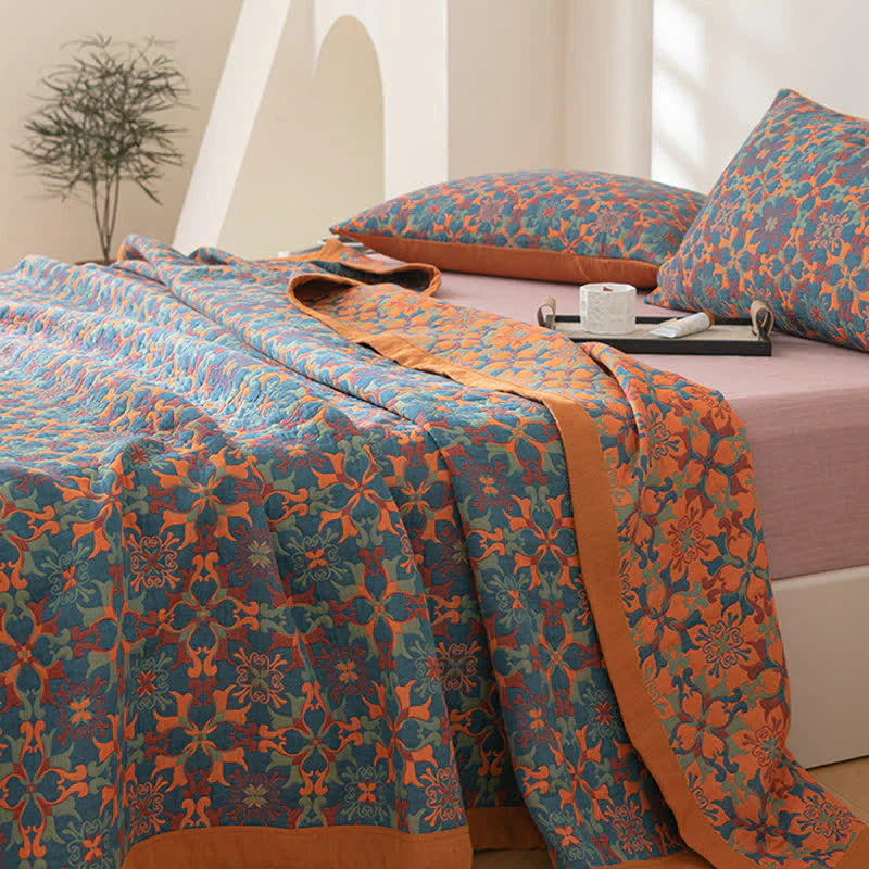Bett mit blau-orange gemustertem Bettüberwurf, Kissen, Tasse und Tablett, Schlafzimmerdekor.