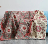 Graue und cremefarbene Decke mit rotem Mandala-Muster auf Sofa, Boho-Stil, Baumwolle.