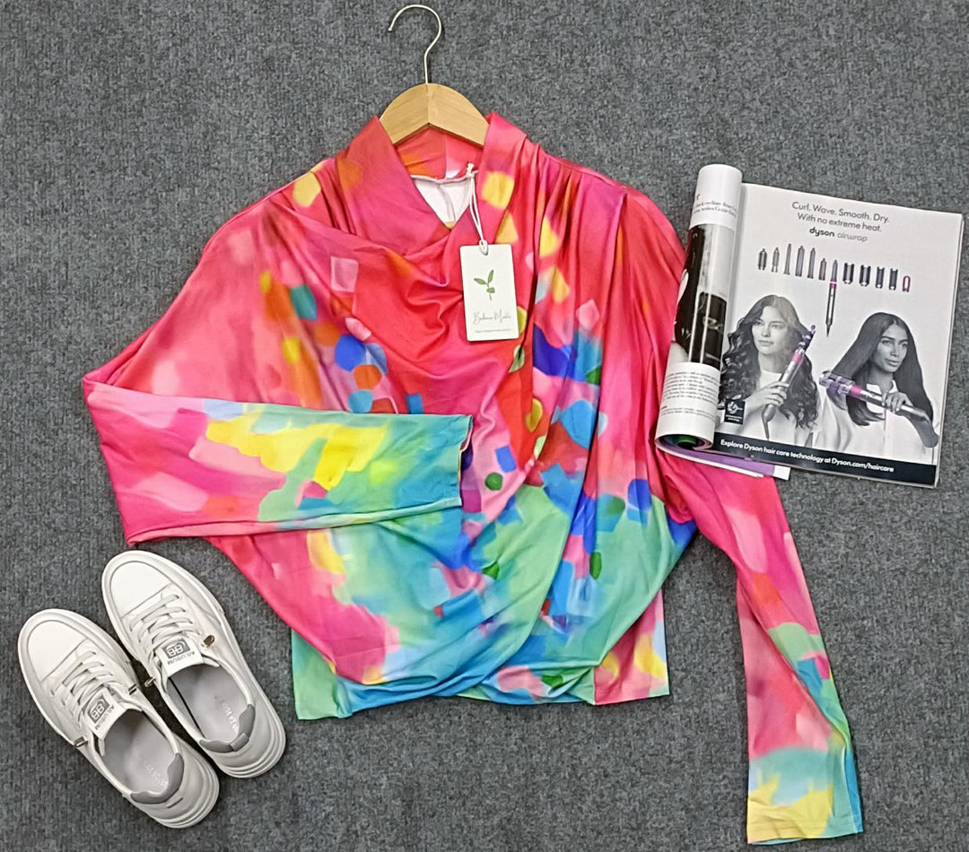 Buntes Damen-Oberteil, abstraktes Muster, auf grauem Hintergrund, mit weißen Sneakers.