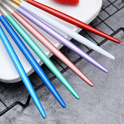 Bunte Edelstahl-Essstäbchen auf Teller, ideal für asiatische Küche, langlebig und stilvoll.