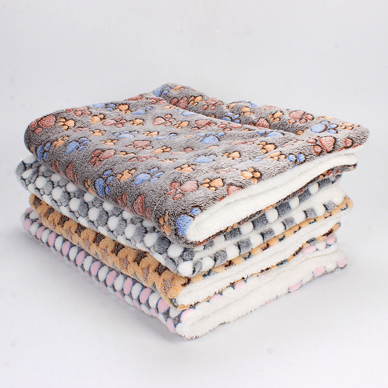 Gestapelte bunte Fleece-Decken mit Pfotenmuster, weich, warm, gemütlich, für Haustiere.