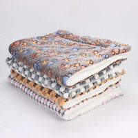 Gestapelte bunte Fleece-Decken mit Pfotenmuster, weich, warm, gemütlich, für Haustiere.