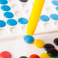 Gelber Stift platziert blaue Perle auf weißem Steckbrett, Bastelset für Kinder, DIY-Spielzeug.