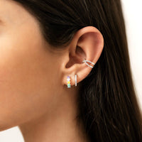 Frau mit bunten Liebe-Ohrringen, silberne Creolen, modischer Schmuck, Nahaufnahme.