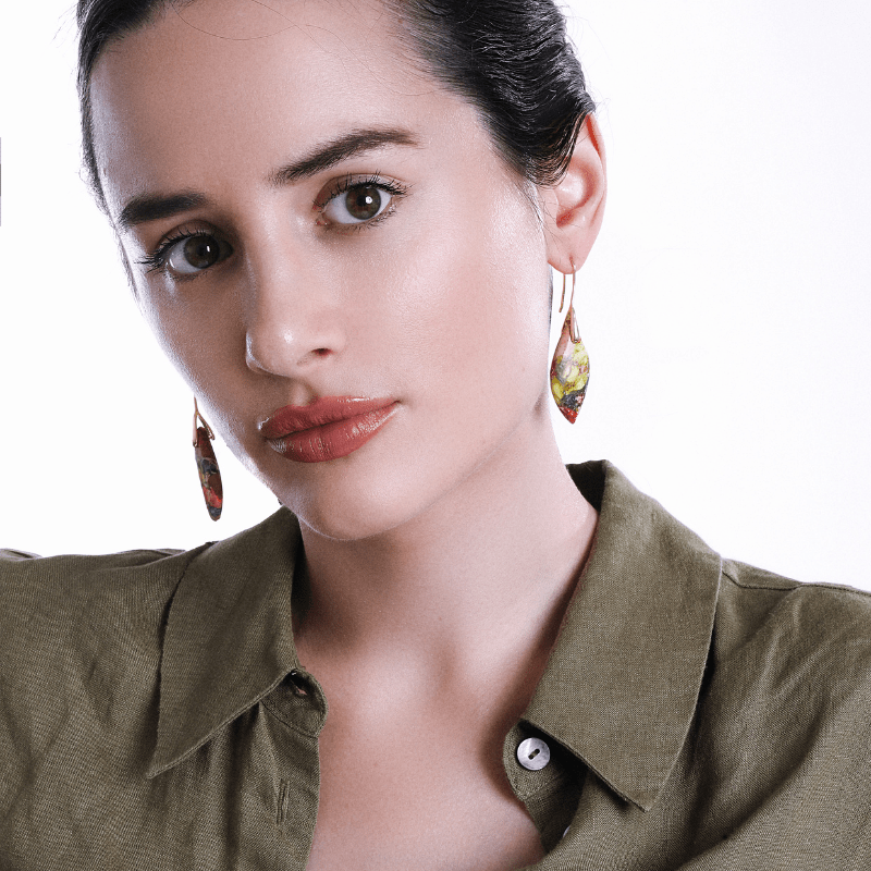 Frau mit bunten Ohrringen und olivgrüner Bluse, Nahaufnahme, Modeaccessoires, Schmuck.
