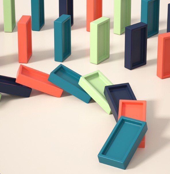 Bunte rechteckige Dominosteine aus Kunststoff, aufrecht und umgefallen, auf hellem Hintergrund.