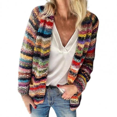 Frau trägt bunten Strickcardigan, weißes Top, Jeans; modische Damenbekleidung.