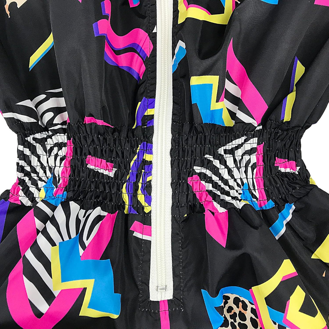 Bunter Retro-Overall mit elastischem Bund, geometrischen Mustern, Reißverschluss, 80er-Jahre-Stil.