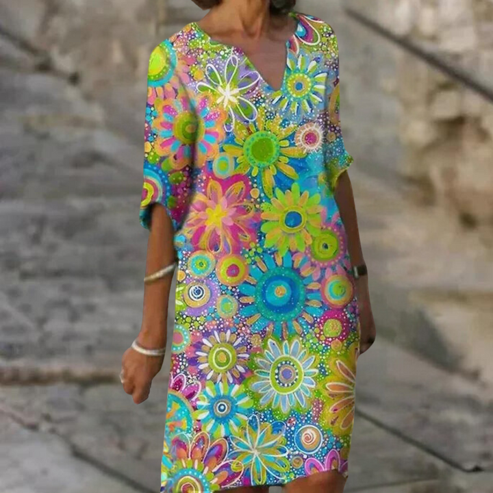 Frau in buntem, geblümtem Sommerkleid auf Straße, modisch, farbenfroh, Freizeitkleidung.