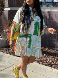 Frau in buntem, gemustertem Hemdkleid und gelben Sandalen spaziert draußen.