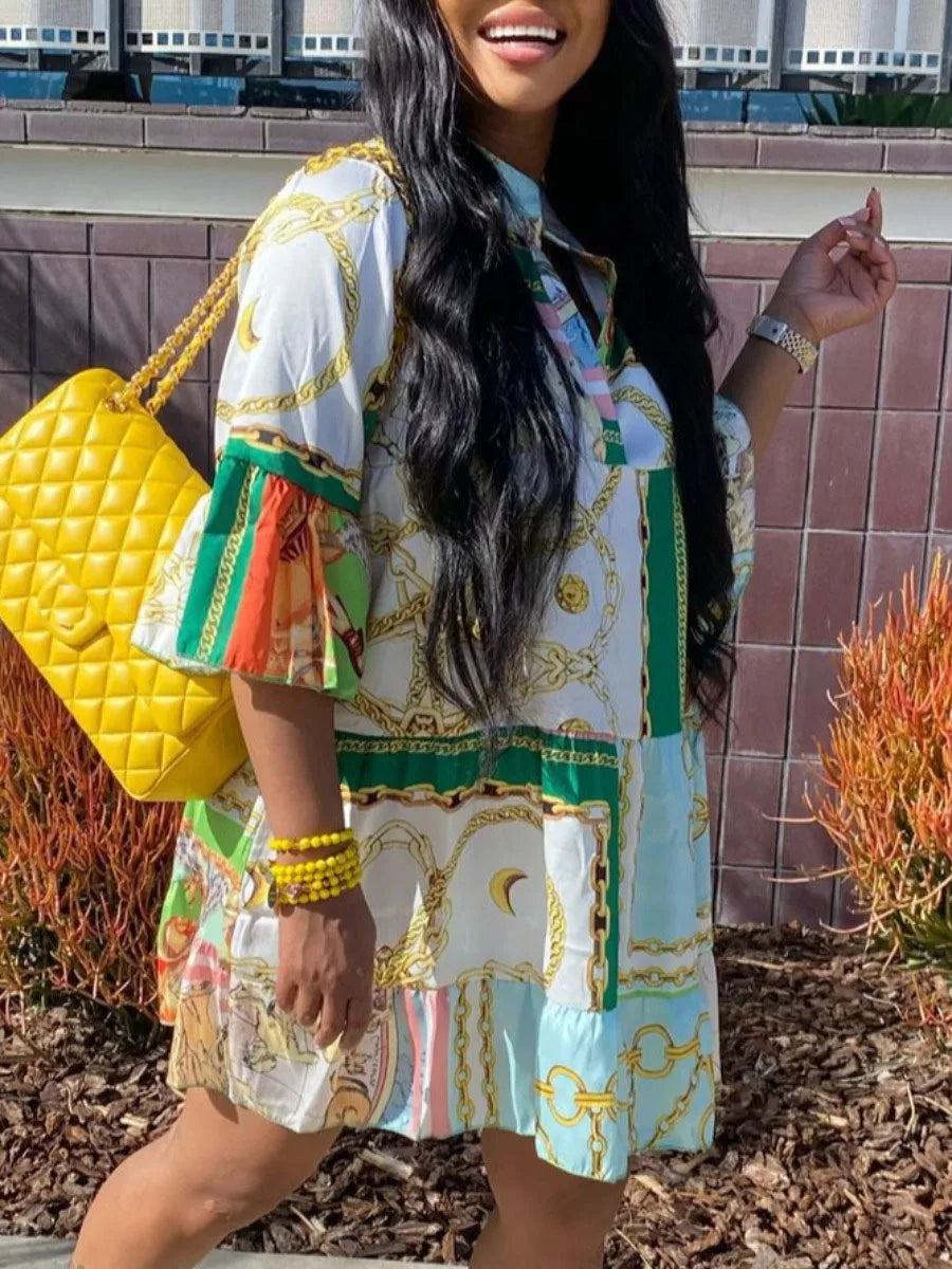 Frau in gemustertem Kleid mit gelber Stepphandtasche und Armband, draußen stehend.