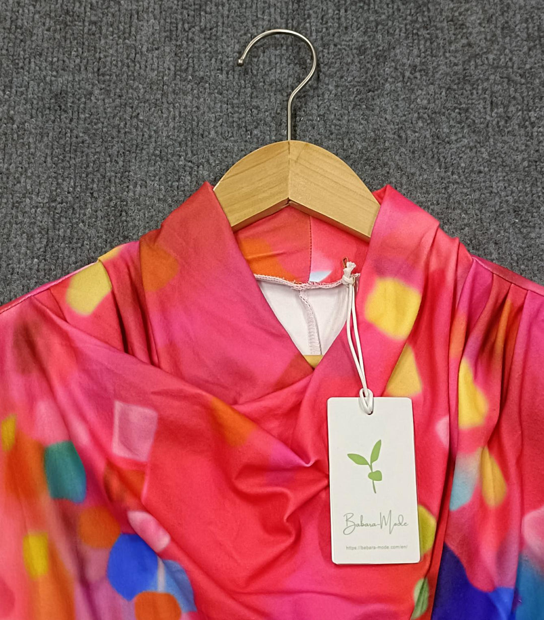 Bunter Kimono auf Holzkleiderbügel, leuchtende Farben, Etikett, grauer Hintergrund.