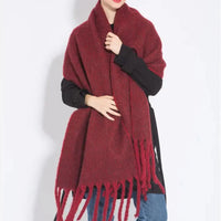 Frau mit burgundrotem Wollschal, Fransen, modisch, warm, Herbst-Winter-Accessoire.
