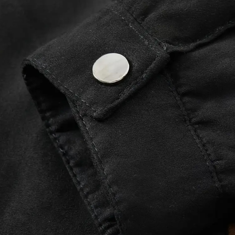 Schwarze Wildlederjacke Detailansicht, silberner Knopf, hochwertige Mode, stilvoll, elegant.