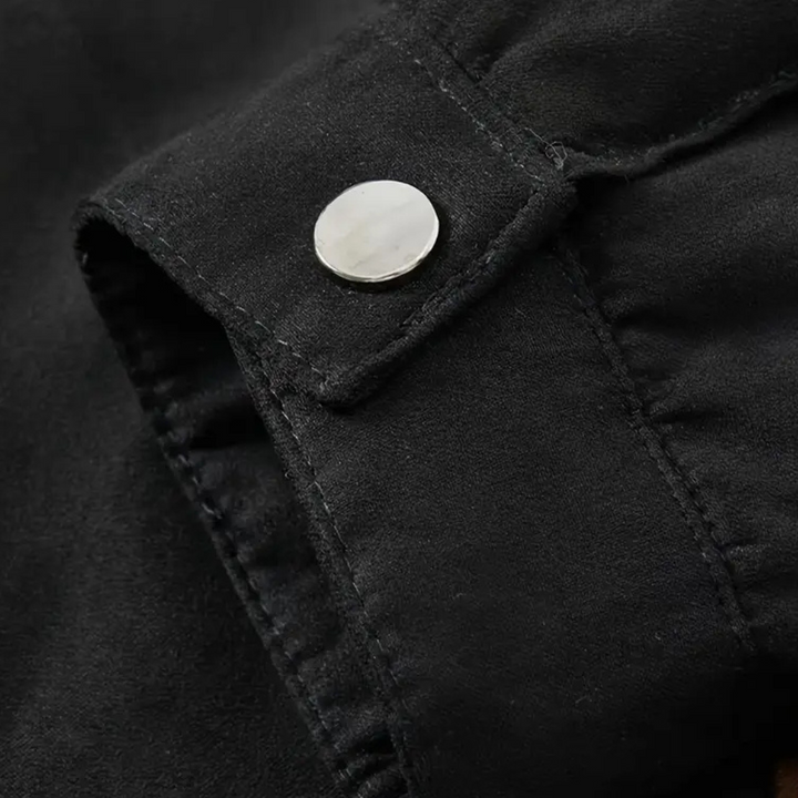 Schwarze Wildlederjacke Detailansicht, silberner Knopf, hochwertige Mode, stilvoll, elegant.