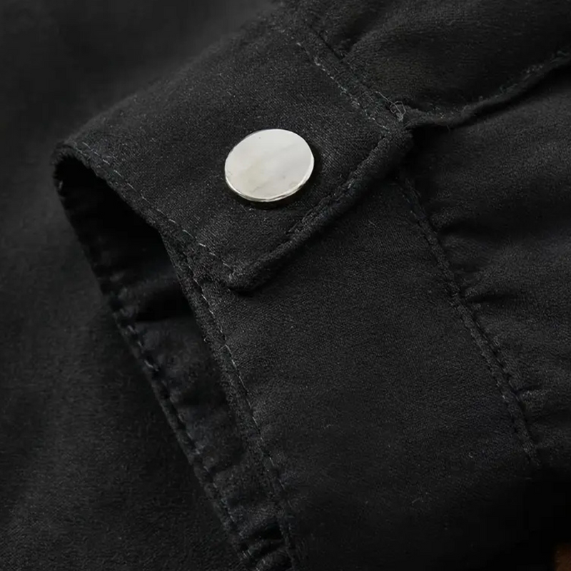 Schwarze Wildlederjacke Detailansicht, silberner Knopf, hochwertige Mode, stilvoll, elegant.