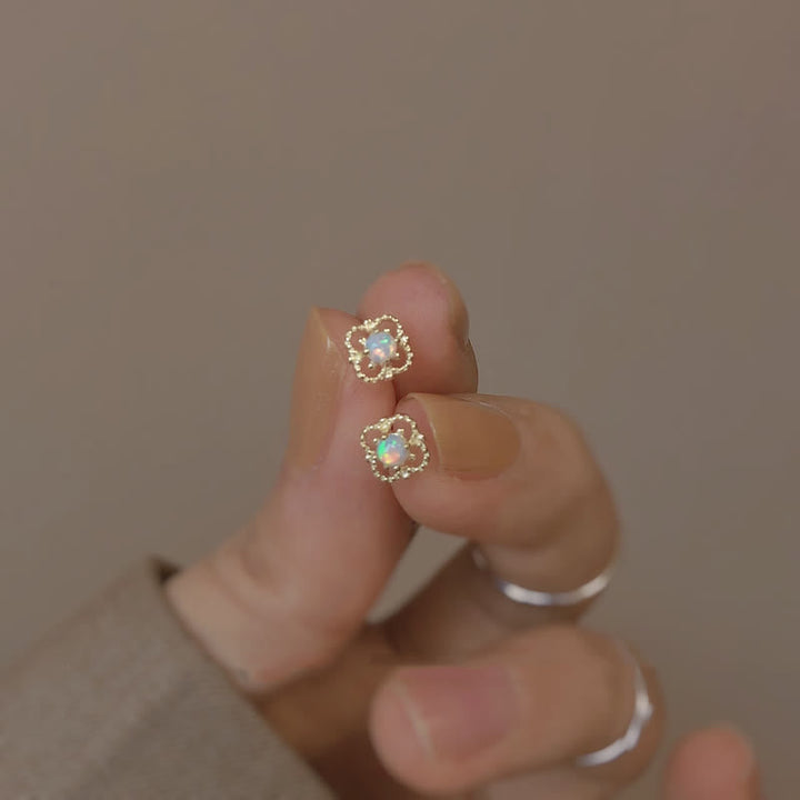 Goldene Ohrringe mit Opal, Blumenform, Damen-Schmuck, elegantes Design, Nahaufnahme.