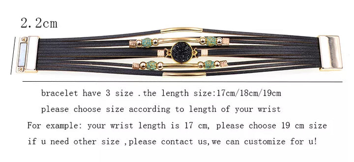 Schwarzes Armband mit goldenen Akzenten und grünen Steinen, verstellbar in drei Größen.