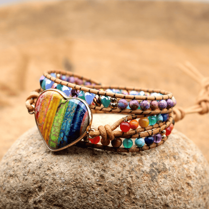 Buntes Chakra-Wickelarmband mit Herzanhänger, handgefertigt, Boho-Stil, auf Stein.
