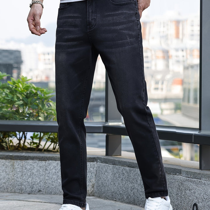 Schwarze Herrenjeans, Slim Fit, aus Denim, urbaner Stil, getragen mit weißen Sneakern.