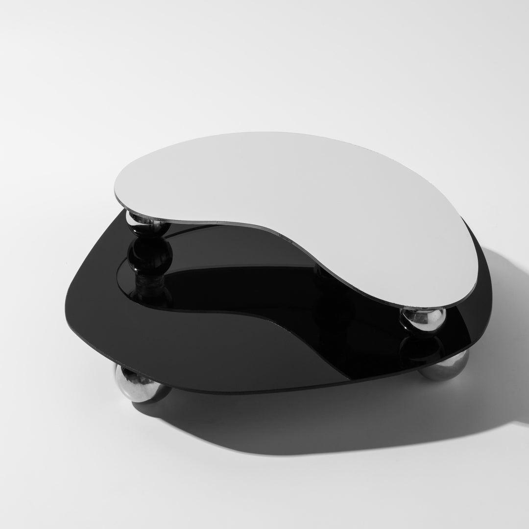 Moderner schwarz-weißer Couchtisch, organische Form, Glasplatten, Chromfüße.