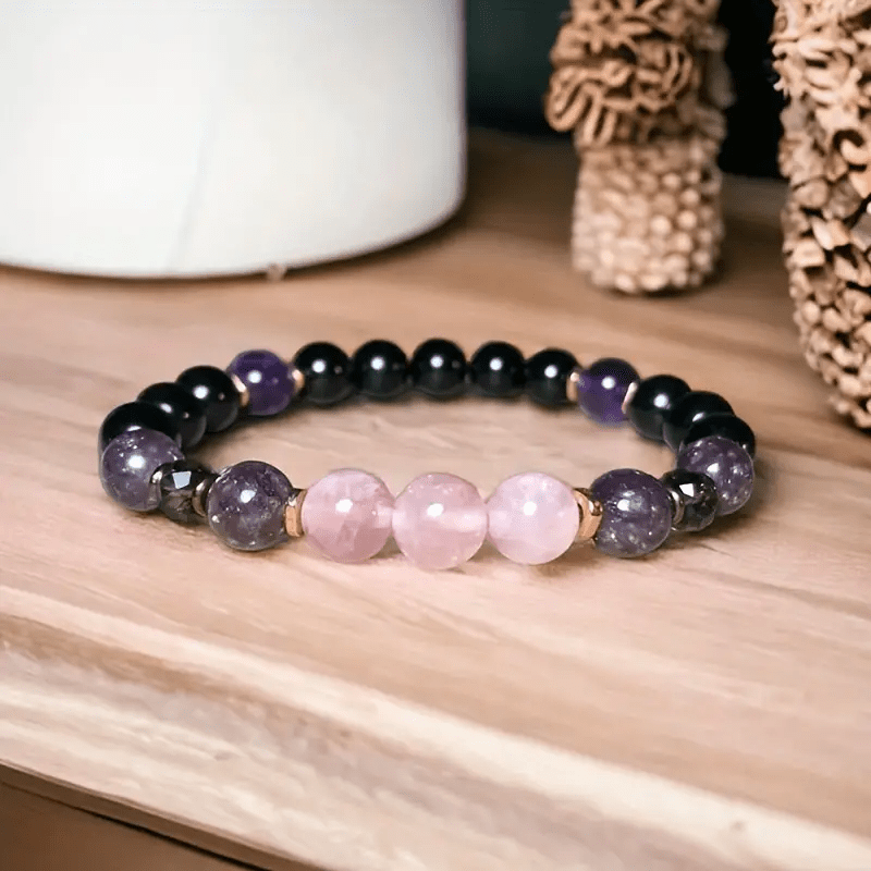 Armband aus Rosenquarz und Amethyst, handgefertigt, auf Holzoberfläche, Schmuckdesign.