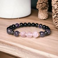 Armband aus Rosenquarz und Amethyst, handgefertigt, auf Holzoberfläche, Schmuckdesign.