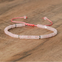 Rosa Perlenarmband mit verstellbarem Verschluss auf Holztisch, Schmuck, Damenaccessoire.