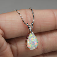 Opal-Anhänger in Tropfenform, Silberkette, schillernde Farben, eleganter Schmuck, Nahaufnahme.