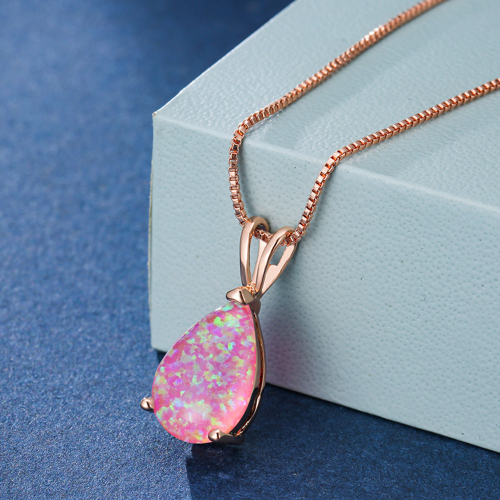 Rosa Opal-Anhänger mit Roségoldkette auf blauem Hintergrund, eleganter Schmuck.